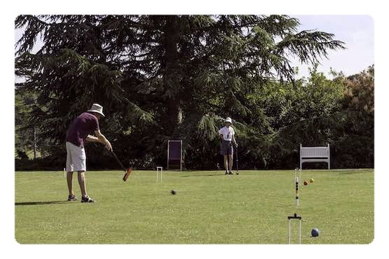 Campo Jogo do Croquet Jogadores a jogar o Jogo do Croquet