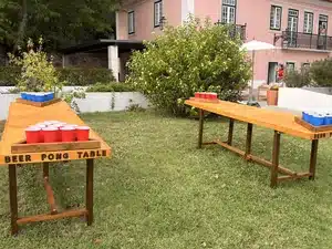 Duas mesas de beer pong para aluguer num jardim, perfeitas para casamentos, aniversários e eventos de empresa